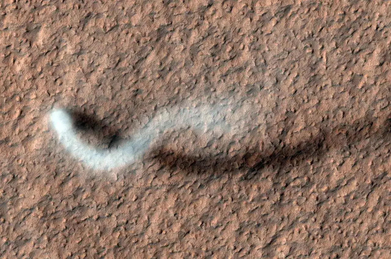 Ein gewaltiger Staubteufel wirft auf diesem Bild, das von der Kamera des High Resolution Imaging Science Experiment (HiRISE) auf dem Mars Reconnaissance Orbiter der NASA aufgenommen wurde, einen schlangenförmigen Schatten auf die Marsoberfläche. Der Staubteufel ist 800 m hoch und 30 m breit.